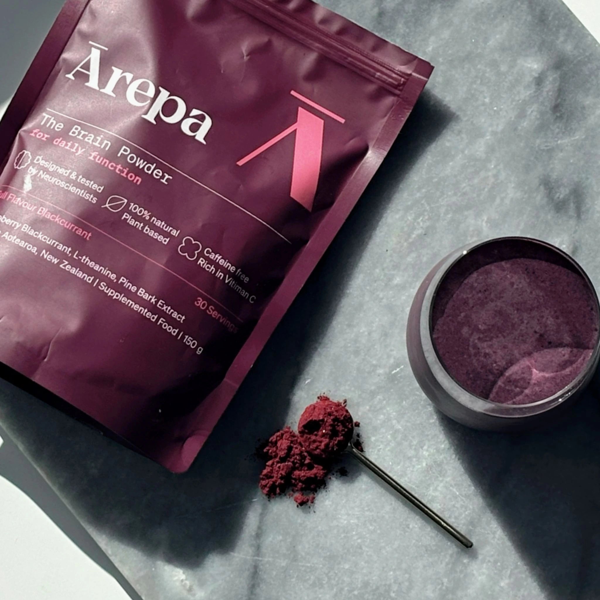 Ārepa Brain Powder pouch with a serving of powder and a smoothie made with protein, berries and Ārepa the brain drink powder.
