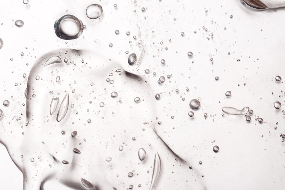 Macro shot of clear hyaluronic acid gel with air bubbles – representing HA Sodium Hyaluronate derived from botanical fermentation, known for its intense hydration, plumping, and skin barrier support.