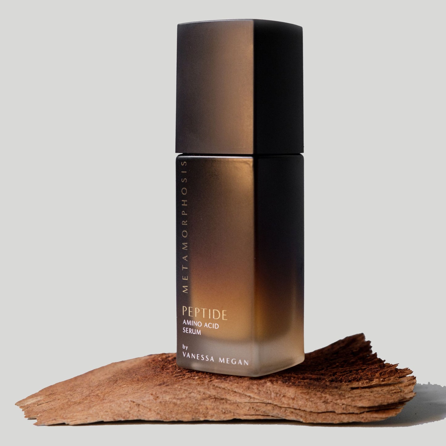 Metamorphosis Peptide Amino Acid Serum by Vanessa Megan – night repair serum for menopausal skin, photographed on a natural wood.