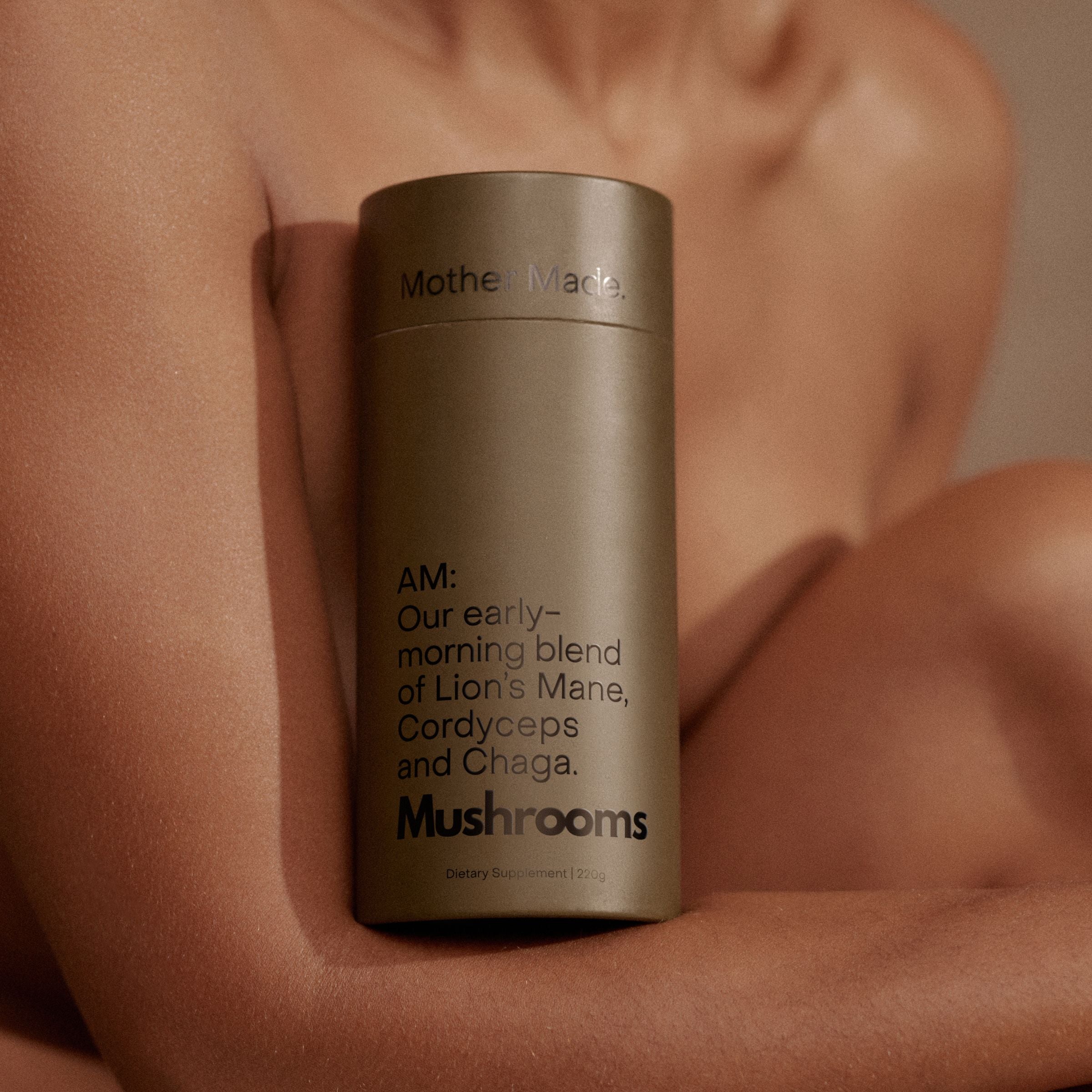Mother Made AM mushroom blend held against skin, highlighting energising and body-supportive ingredients like Lion’s Mane, Cordyceps and Chaga