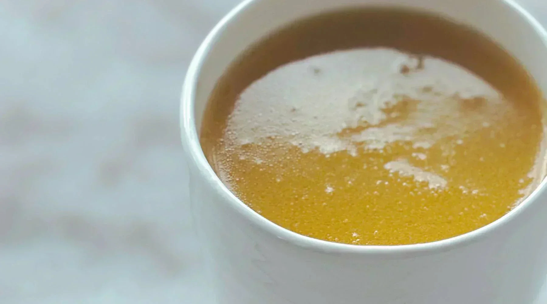 The Perfect Bone a nourishing golden bone broth in a ceramic mug – rich in collagen, amino acids, and minerals for gut health and immune support