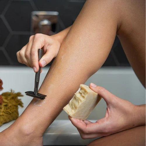 Women shaving legs with CaliWoods reusable razor and that CaliWoods saving soap bar