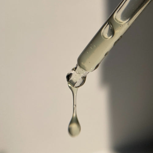 Face serum dripping from dropper