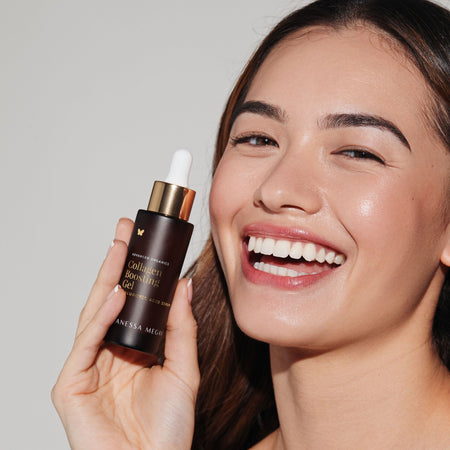Smiling model holding Vanessa Megan Collagen Boosting Gel Hyaluronic Acid Serum.