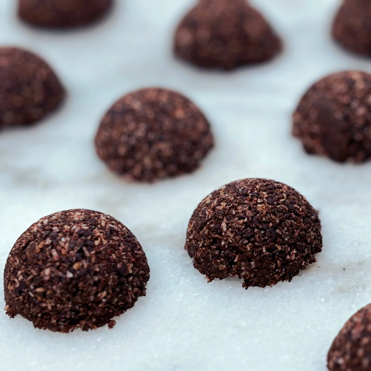 Our  Intentionally Natural Homemade macaroons infused with Ārepa Brain Powder, rich in Neuroberry® blackcurrant and antioxidants, set on a white marble background. Recipe in our recipe journal.