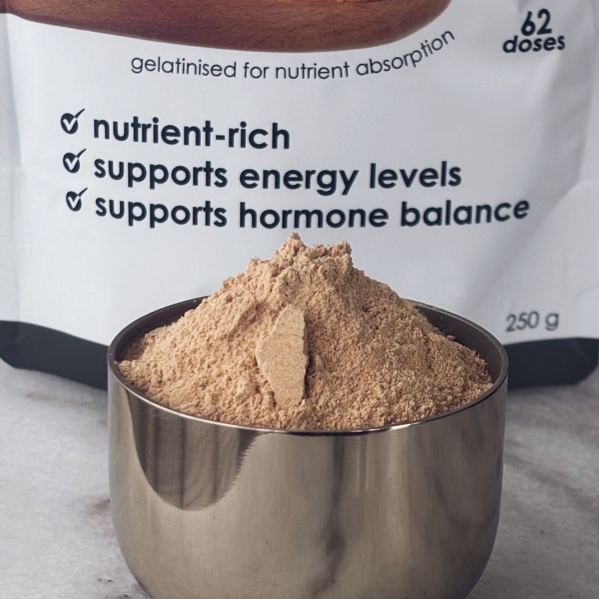 Matakana Superfoods Black Maca Root Gelatinised Powder pouch with the powder also in a gold dish. 