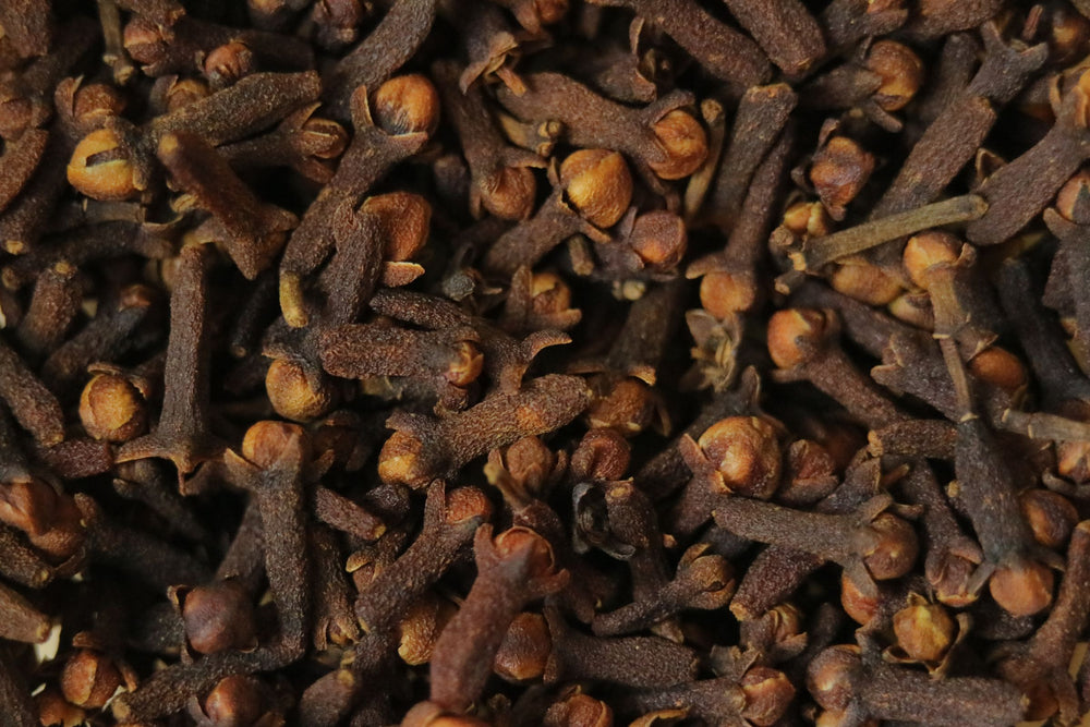 Macro view of aromatic dried clove buds showing natural texture used in botanical health and oral care formulations.
