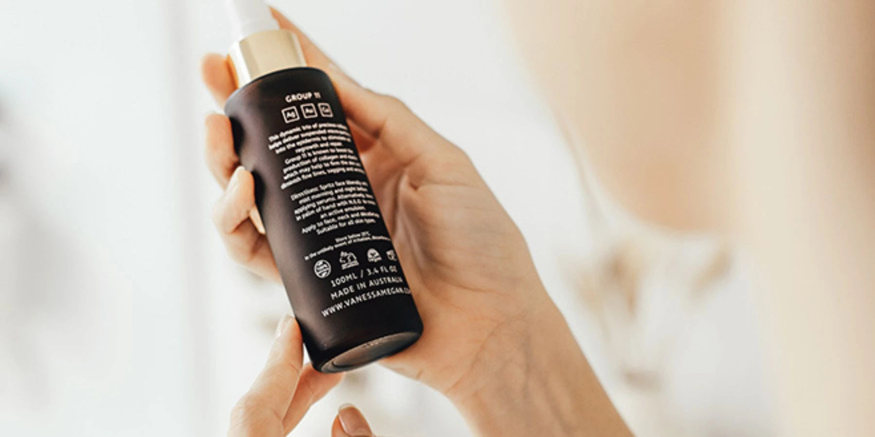 Person holding a Vanessa Megan natural skincare bottle – close-up image used on Intentionally Natural FAQ page to represent product questions and customer support clarity