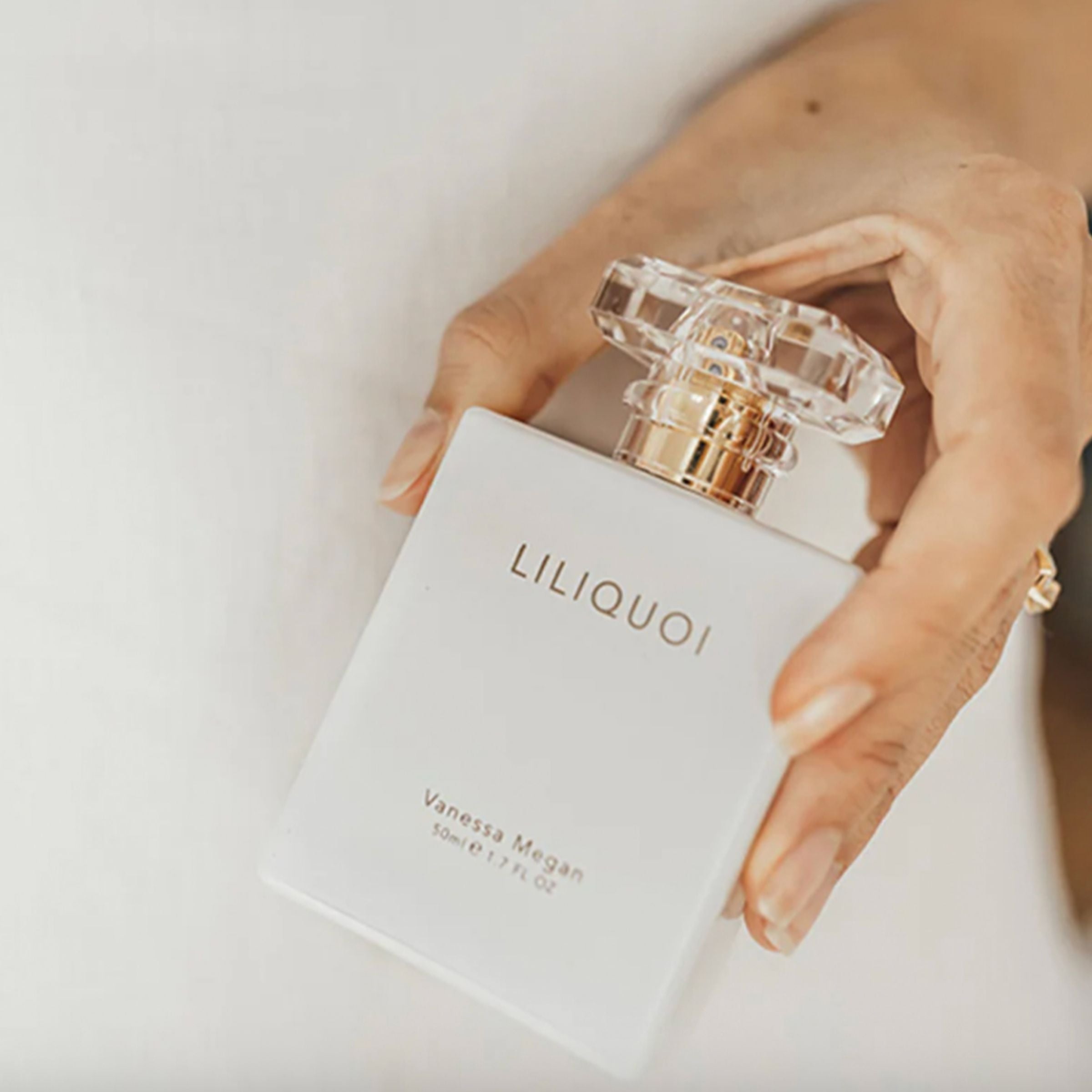 Hand holding Vanessa Megan Liliquoi 100% Natural Perfume bottle.