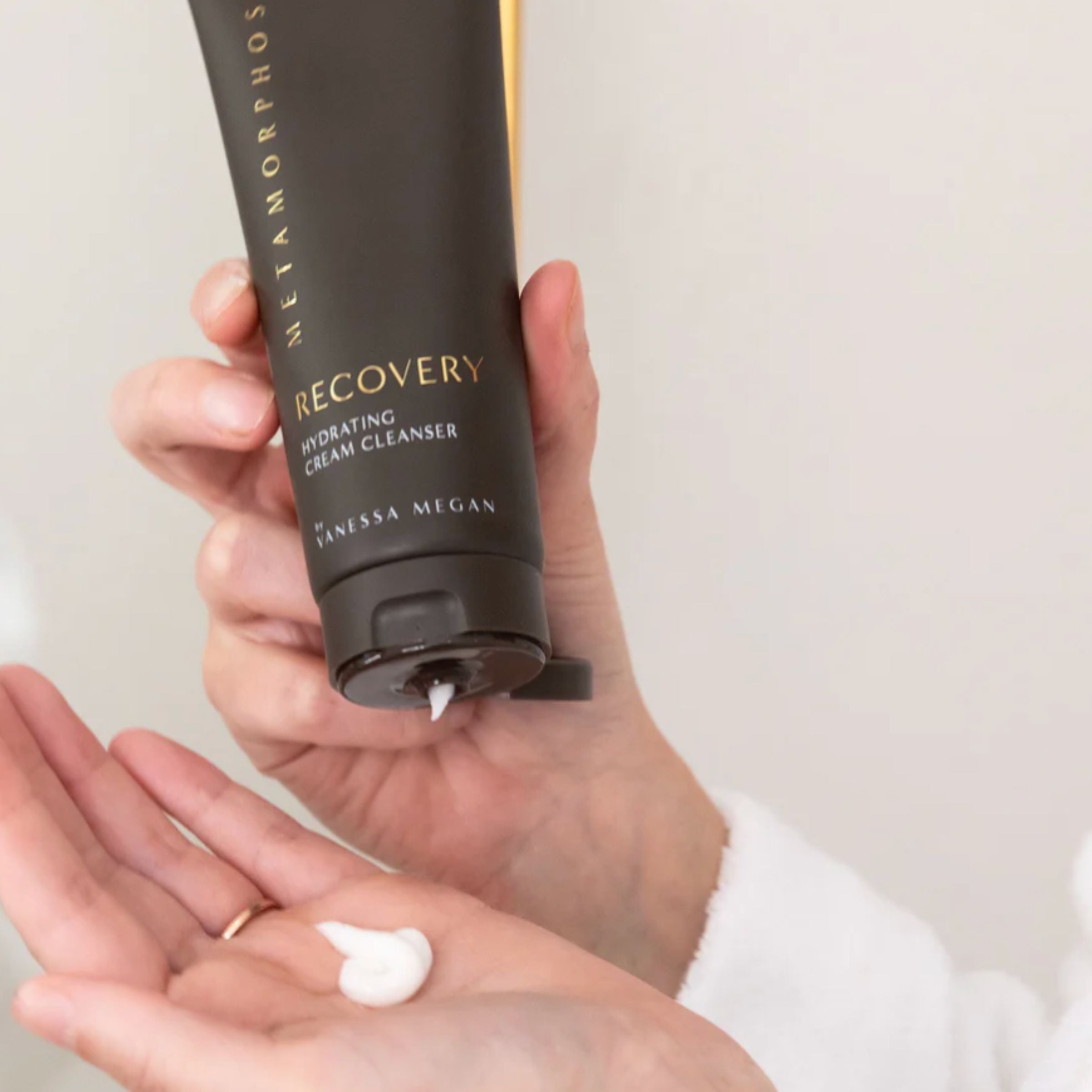 Hand dispensing Metamorphosis Recovery Hydrating Cream Cleanser by Vanessa Megan, showcasing its creamy texture.