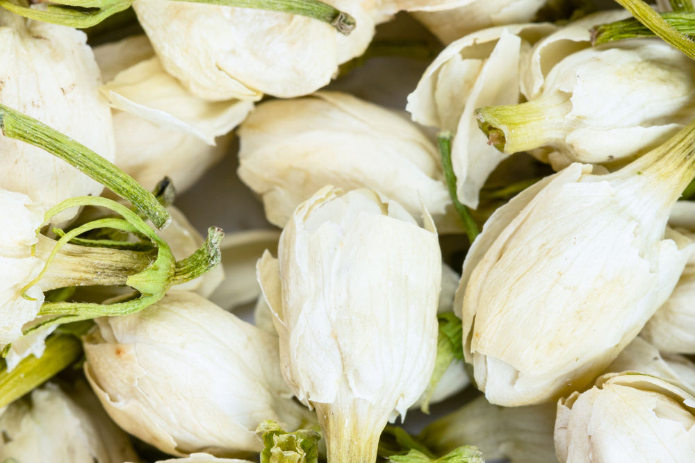 Close up of dried jasmine flower buds used to scent loose leaf green tea and herbal tea blends.