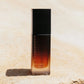 Vanessa Megan Re-Gen Cell Repair Oil pump bottle with Bakuchiol photographed on natural sand