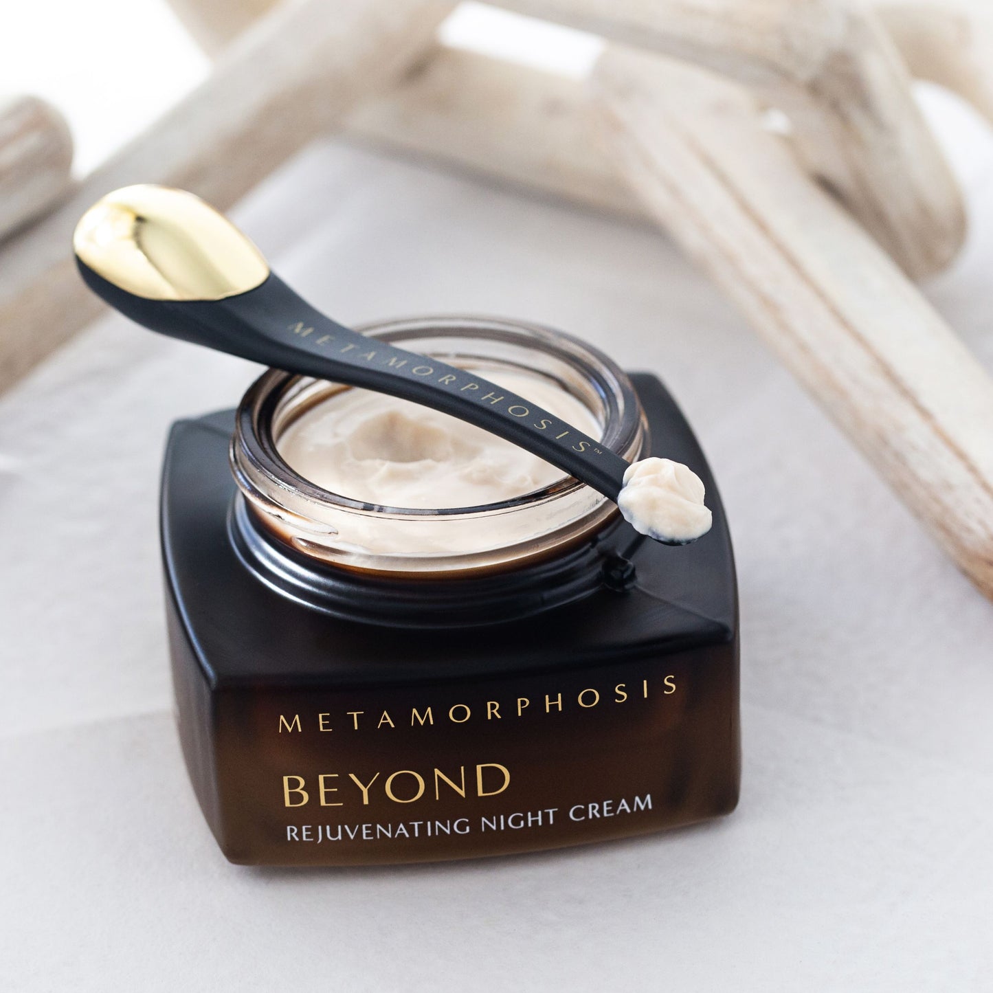 Open jar of Metamorphosis Beyond Rejuvenating Night Cream with applicator, showing rich texture of natural night cream for menopausal skin.