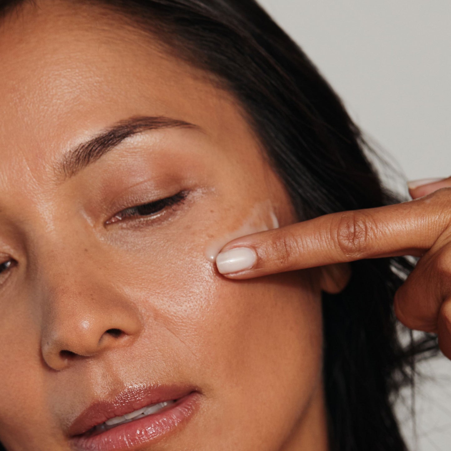 Metamorphosis Chrysalis Serum by Vanessa Megan being gently applied to the cheek – hydrating skincare for menopausal skin.