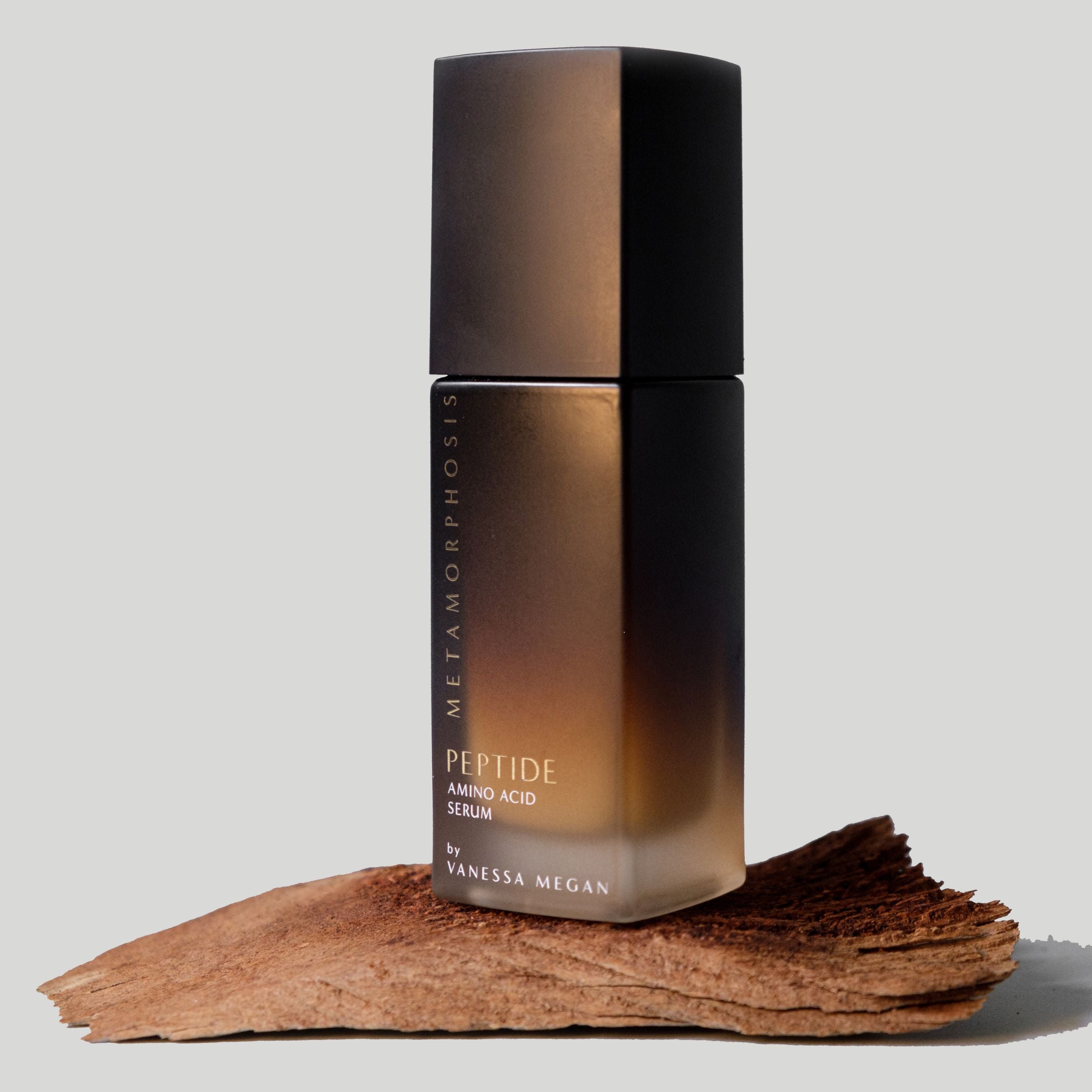 Metamorphosis Peptide Amino Acid Serum by Vanessa Megan – night repair serum for menopausal skin, photographed on a natural wood.
