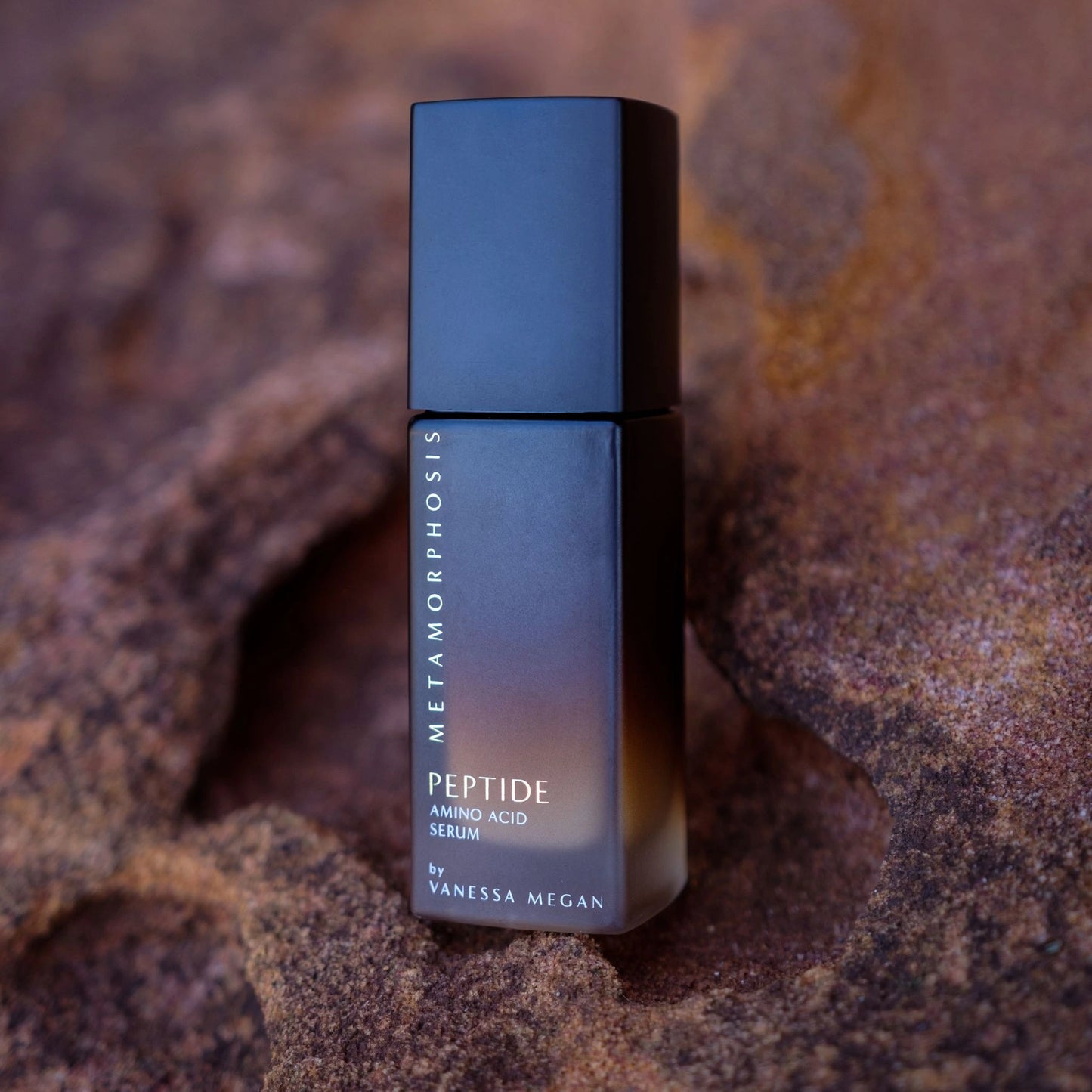 Vanessa Megan Peptide Amino Acid Serum displayed on natural rock