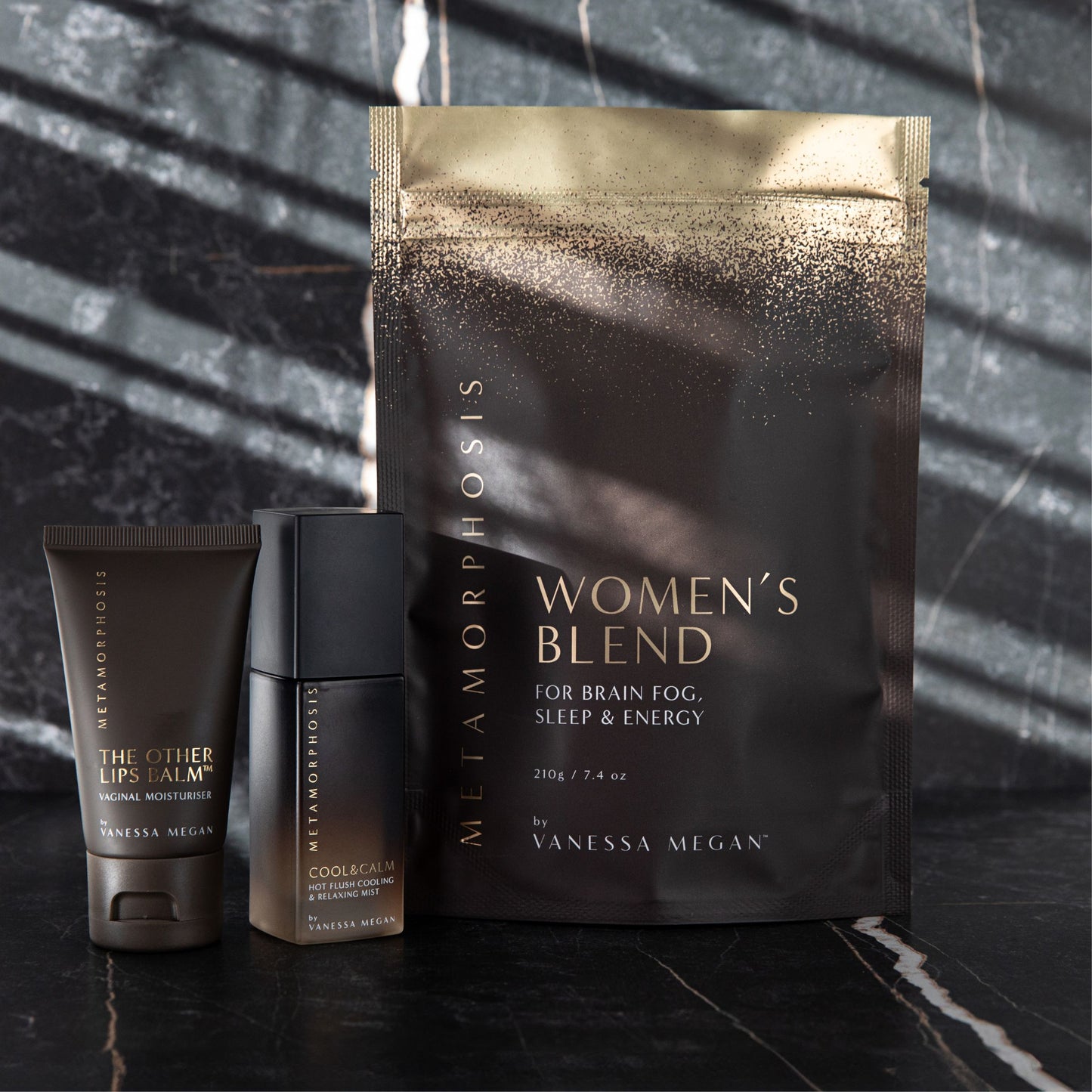 Vanessa Megan Metamorphosis Women's Blend supplement with Cool & Calm mist and The Other Lips Balm, styled on dark marble – formulated for brain fog, sleep, and energy during peri to post-menopause.