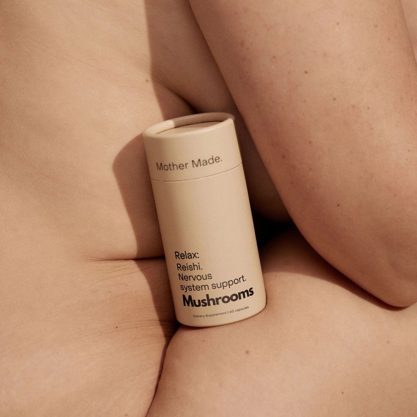 Mother Made Relax Reishi Capsules resting against bare skin to support natural calm and nervous system balance