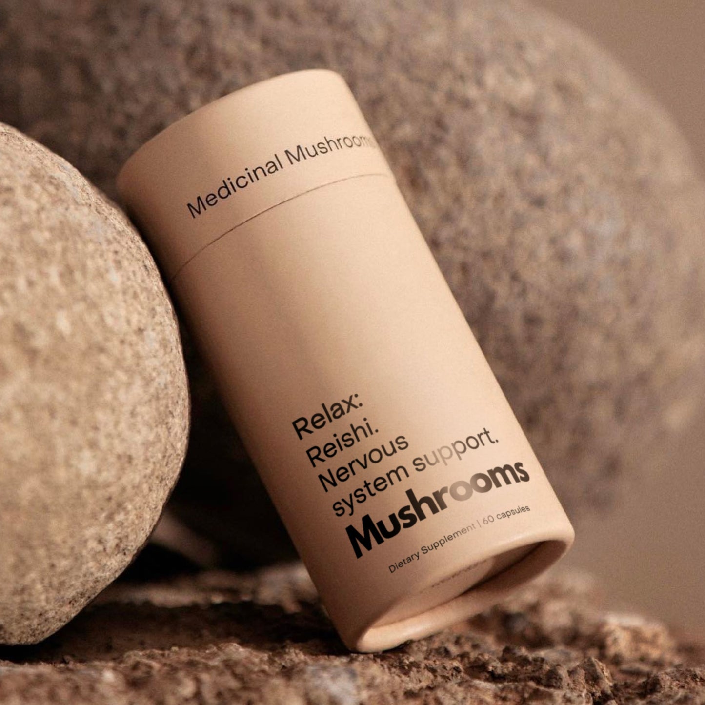 Close-up of Mother Made Reishi mushroom capsules resting against natural stone, designed for relaxation and nervous system support
