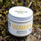 No3 Underbalm Magic Orange & Lime, a magnesium-based natural deodorant in a glass jar, placed on a bed of fresh greenery.