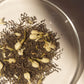 On Sundays Loose leaf blend of  the organic jasmine flowers and premium green tea leaves in a glass dish, highlighting the purity and natural composition of On Sundays Green Jasmine Tea.