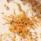A detailed shot of Unwind loose leaf tea ingredients including chamomile flowers, calendula petals, and calming herbs, highlighting the natural texture and colour.