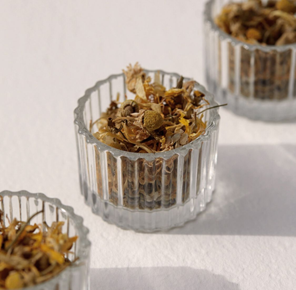 On Sundays Unwind Lose Leaf Organic Tea blend of organic chamomile, calendula, and lavender in glass jars.