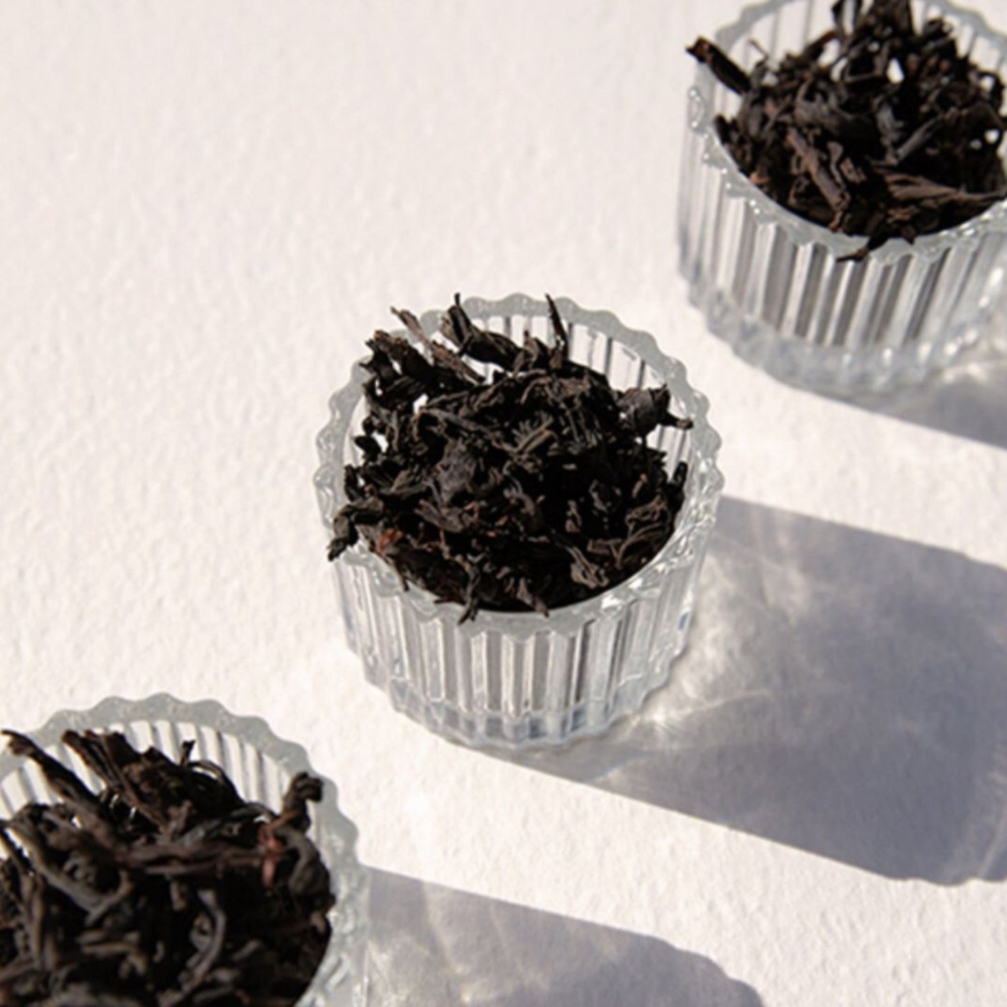 On Sundays English Breakfast organic loose leaf black tea leaves in glass bowls.