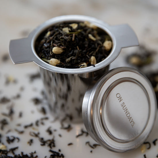 On Sundays Green Jasmine organic loose leaf green tea with whole jasmine flower buds in the On Sundays 304 graded reusable stainless steel tea infuser.