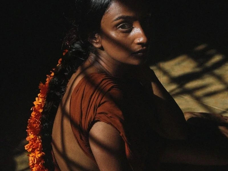 Woman in earthy tones with marigold garland