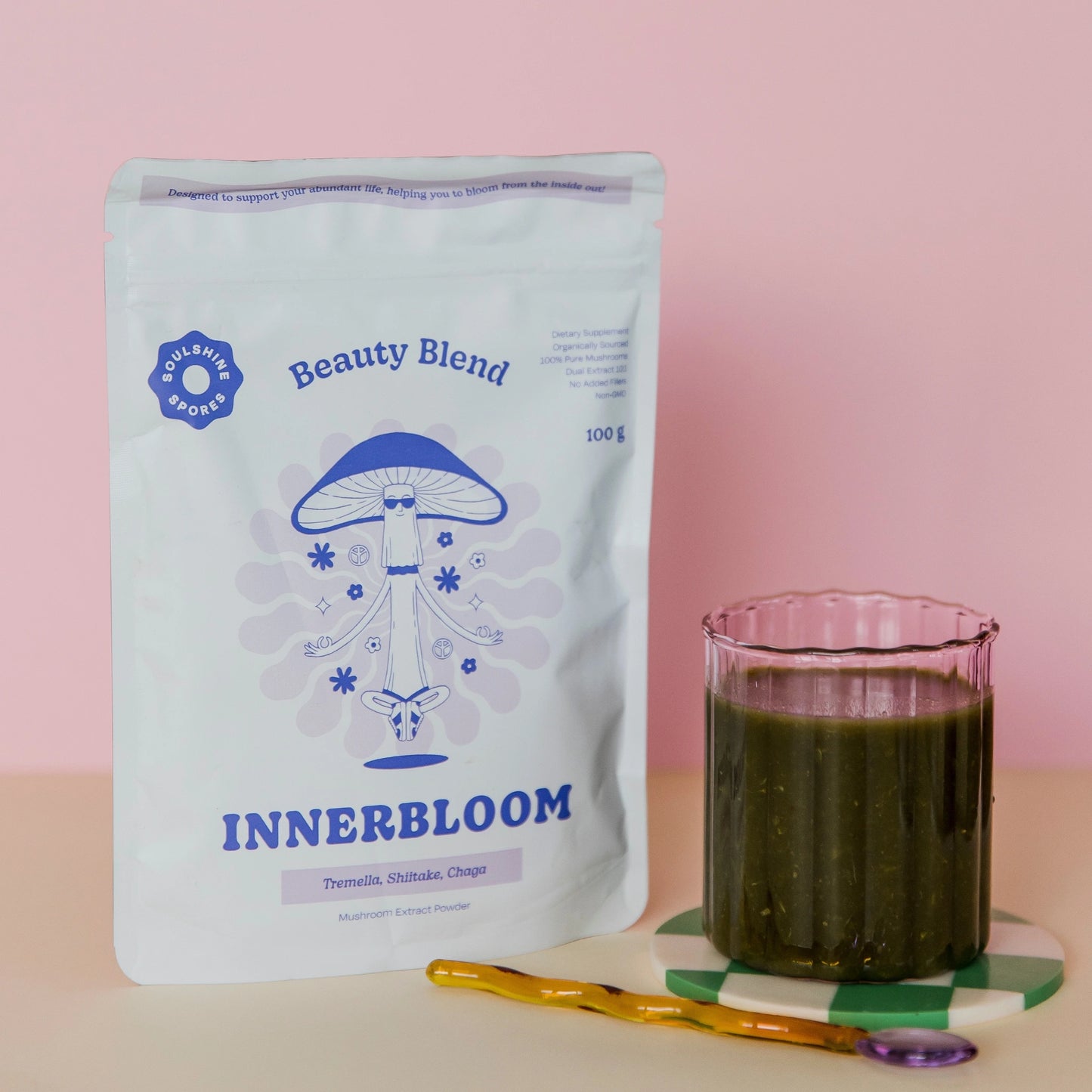 Soulshine Spores InnerBloom Beauty Blend pouch displayed next to a glass of green smoothie.