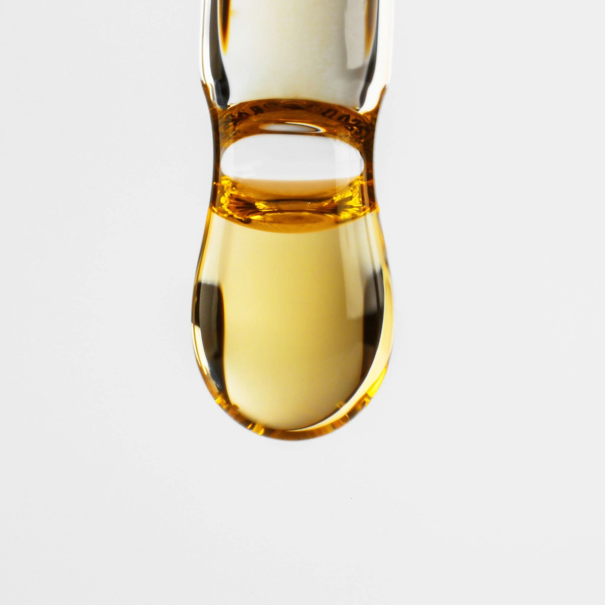 A droplet of therapeutic-grade essential oil suspended in mid-air.