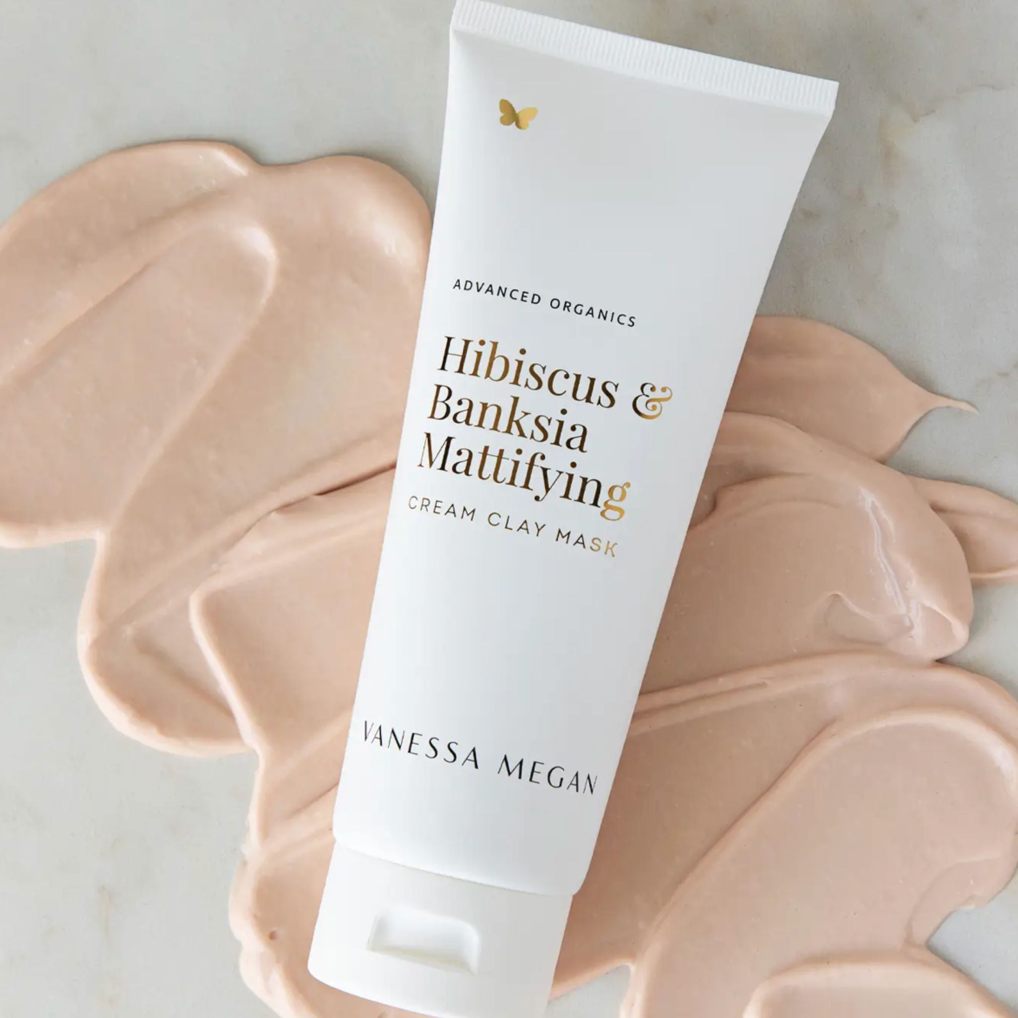 Vanessa Megan Hibiscus and Banksia Mattifying Cream Clay Mask in recyclable sugarcane squeeze tube over creamy clay texture.