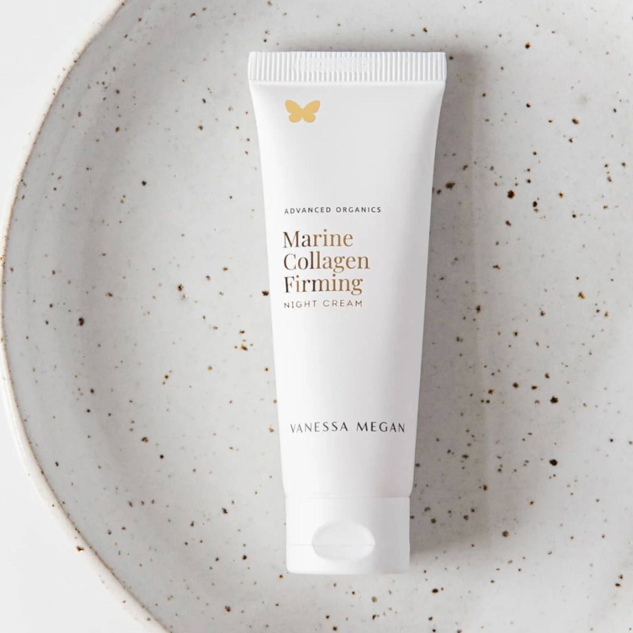 Vanessa Megan Marine Collagen Firming Night Cream in recyclable sugarcane tube packaging displayed on a speckled ceramic dish.