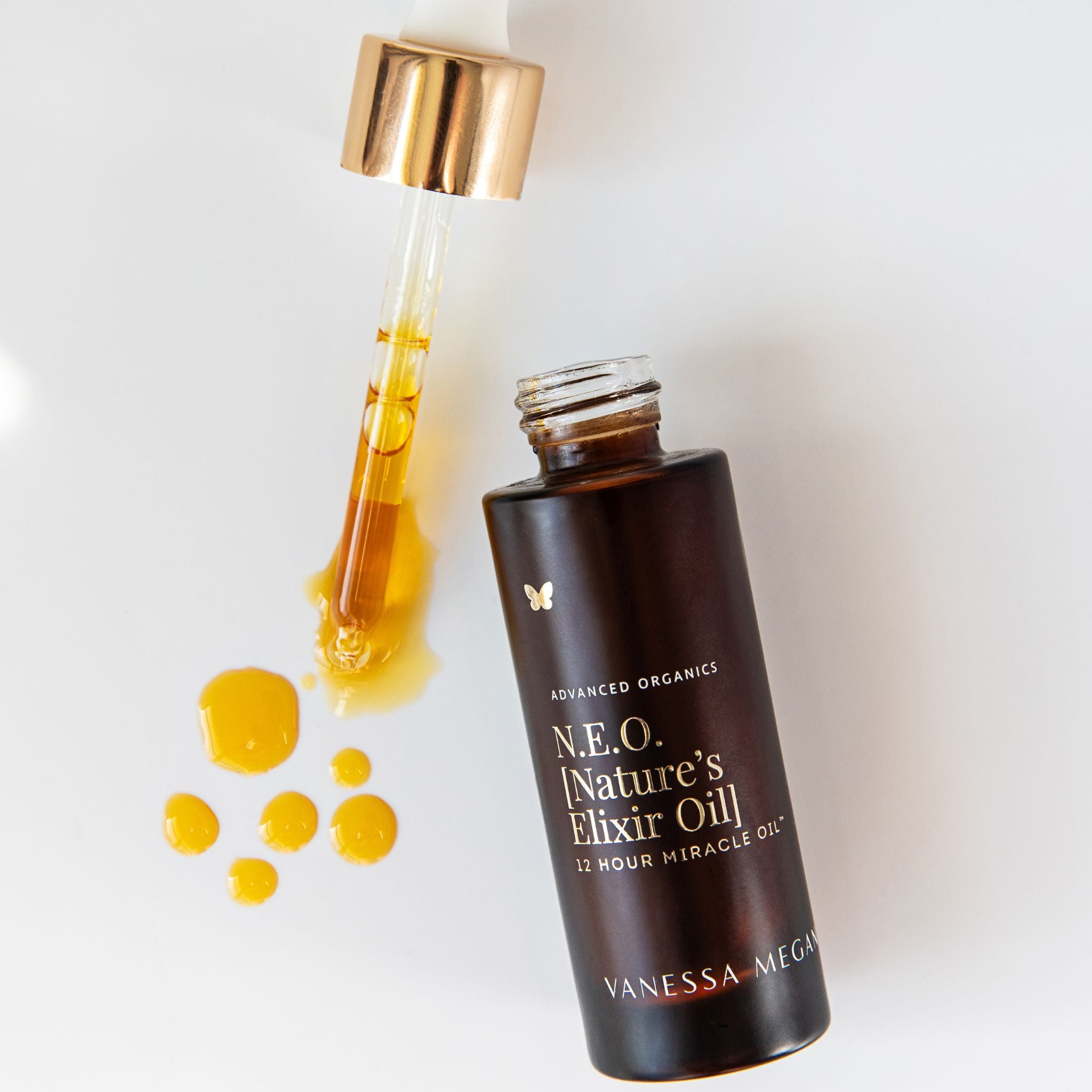 Vanessa Megan N.E.O Nature’s Elixir Oil 12 Hour Miracle Oil with glass dropper and golden botanical facial oil droplets on a clean white background.