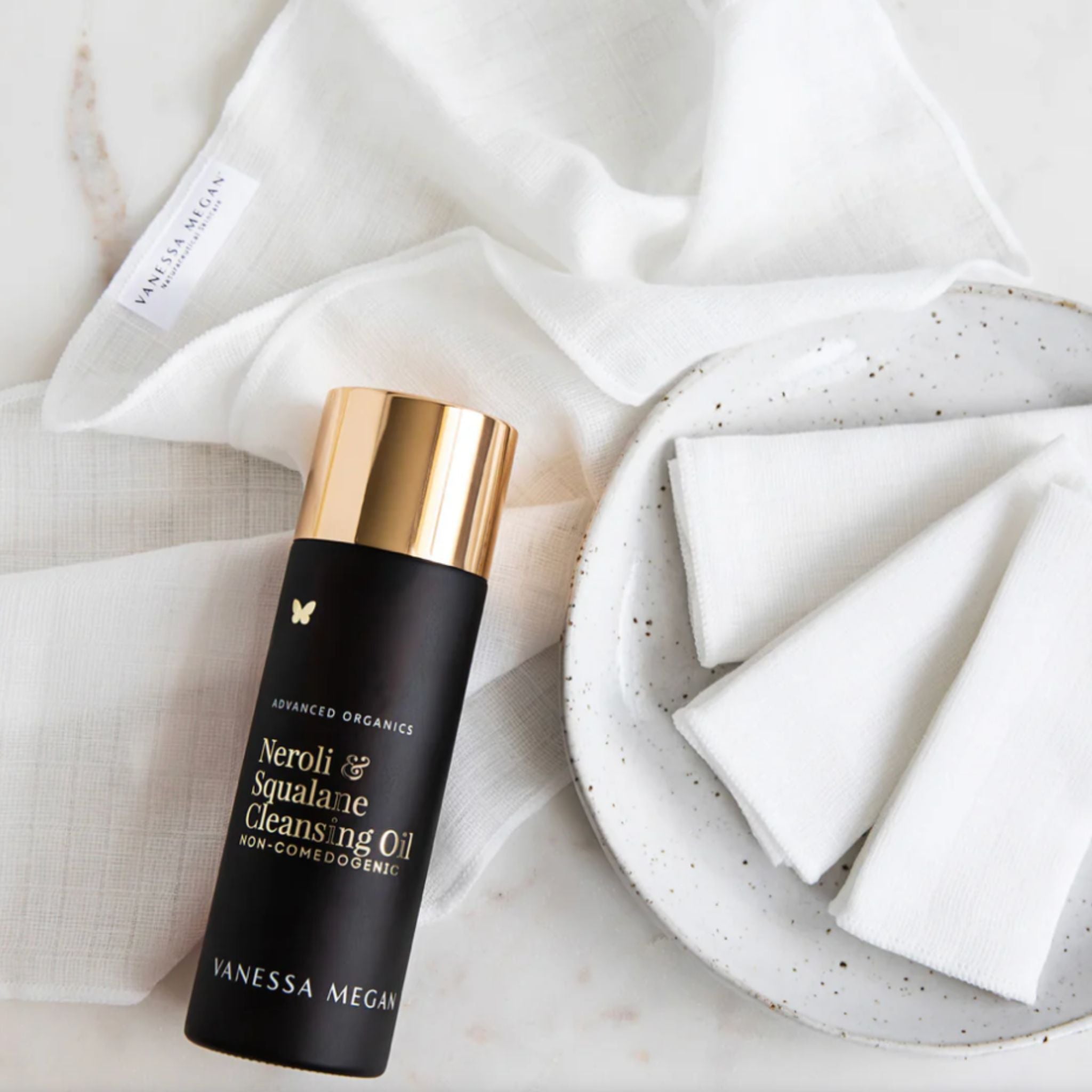 Vanessa Megan Neroli and Squalane Cleansing Oil with reusable cotton pads on a ceramic plate.