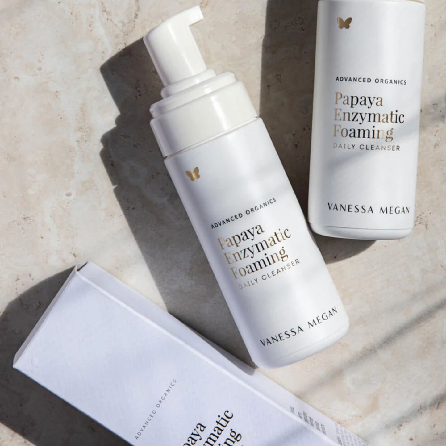 Vanessa Megan Papaya Enzymatic Foaming Daily Cleanser with product packaging displayed on natural stone surface.