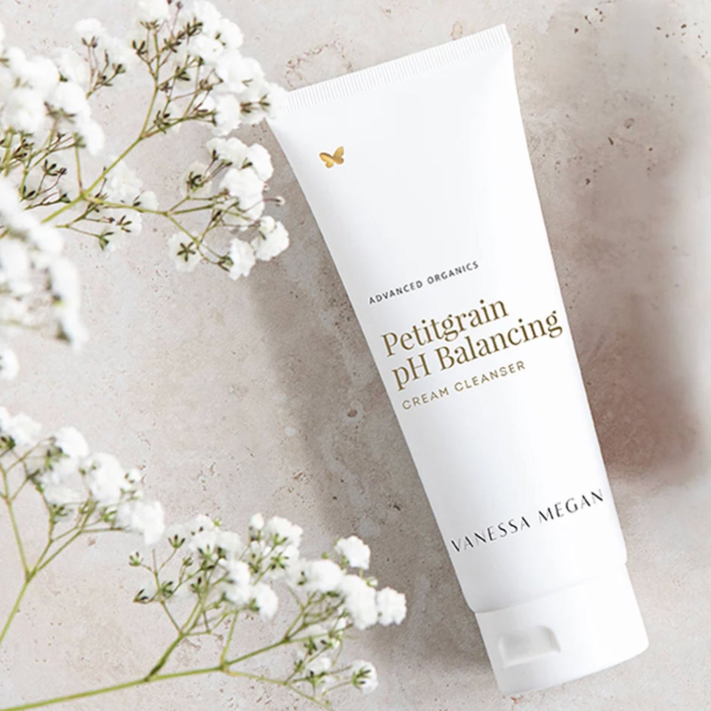 Vanessa Megan Petitgrain pH Balancing Cream Cleanser flatlay with baby's breath – gentle organic face wash for sensitive skin.