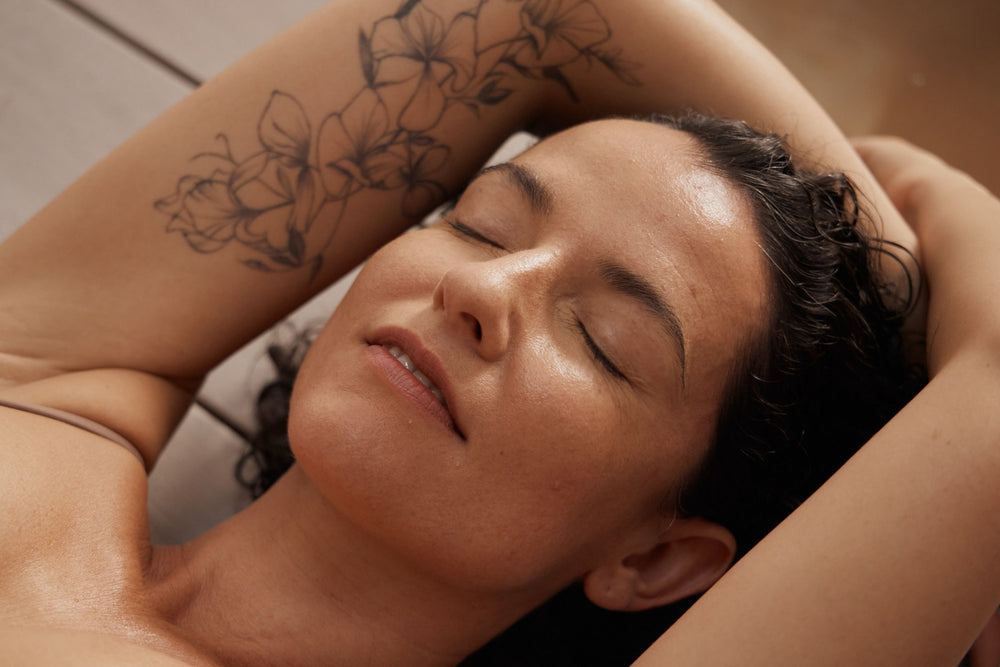 Woman with healthy radiant skin resting peacefully, reflecting the nourishing benefits of botanical skincare and daily skin renewal.