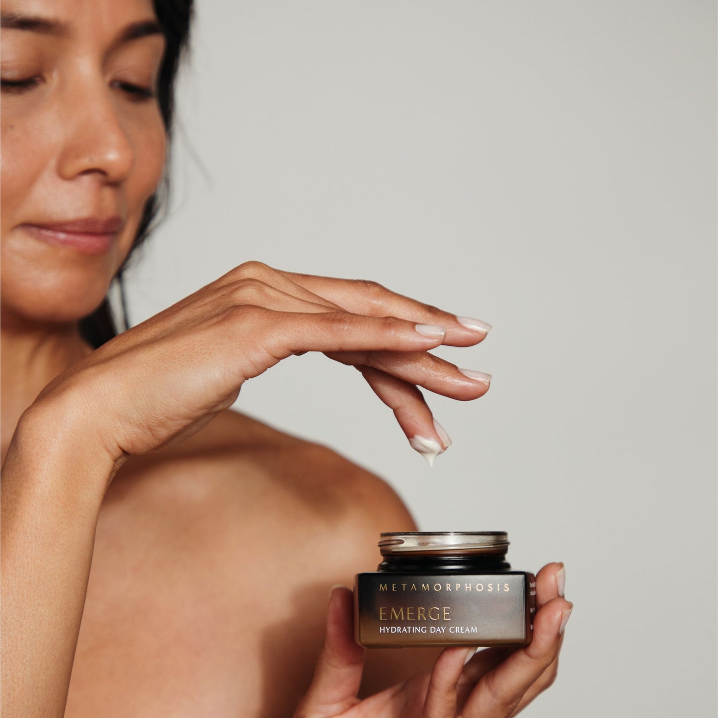 Woman using Metamorphosis Emerge Hydrating Day Cream, showing the creamy texture of the natural moisturiser designed to hydrate and protect peri to post-menopausal skin.