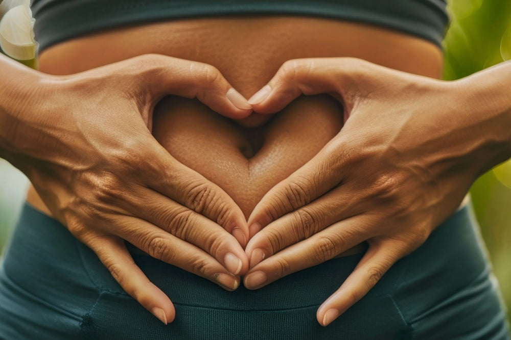 Women making hand heart on tummy  outside in nature.