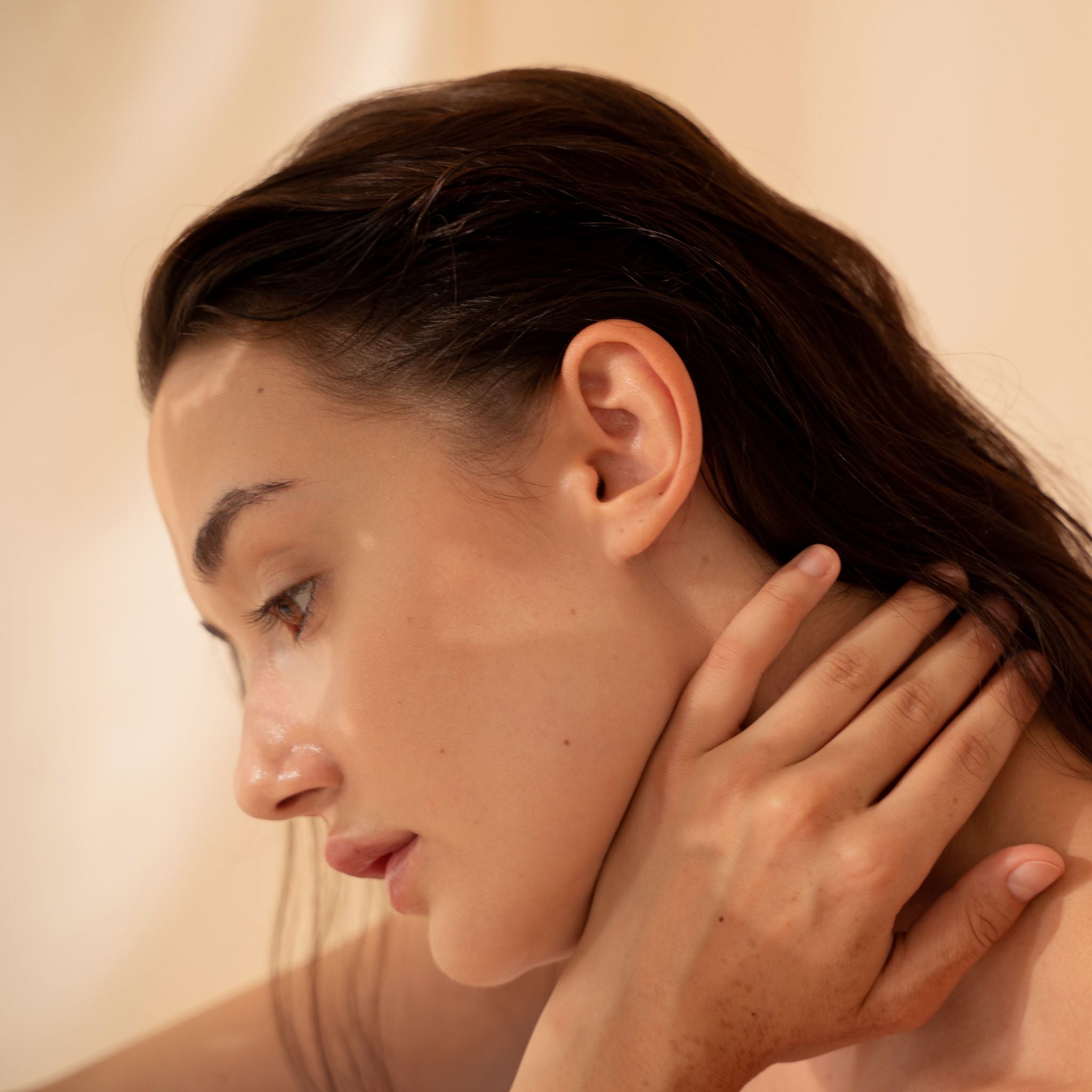 Woman with naturally radiant, dewy skin in soft natural light, representing healthy hydration, nourishment and skin vitality.